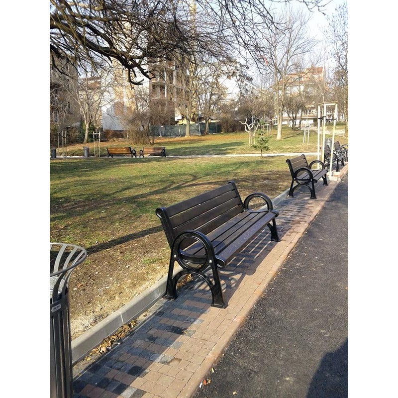 Дървена градинска пейка в парк, идеална за отдих и социализиране на открито.
