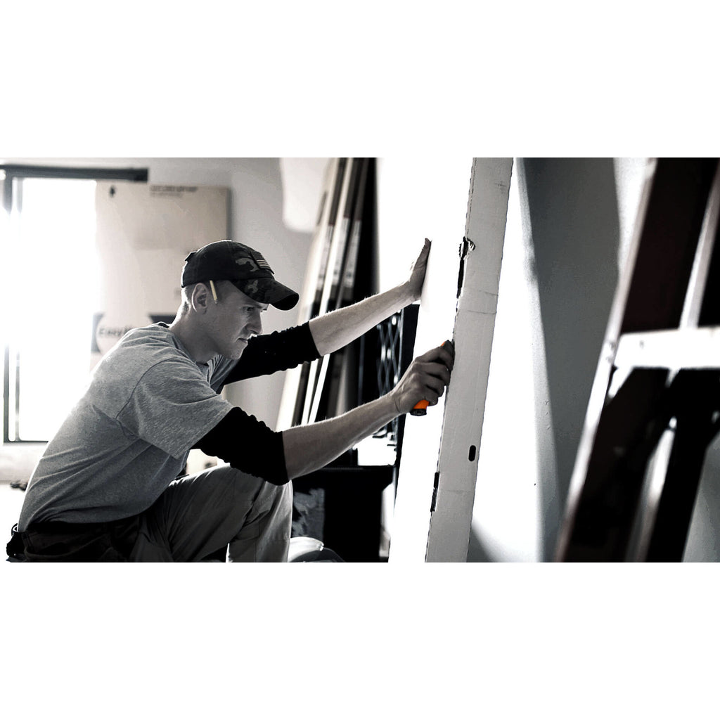 Макетен нож с прибиращо се острие Fiskars Pro CarbonMax™ използван при прецизно рязане на гипсокартон от работник