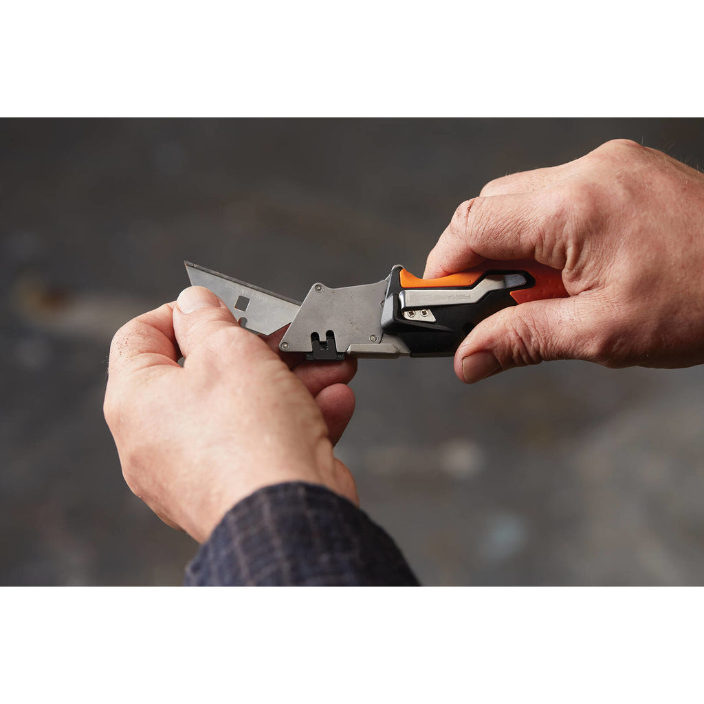 Сгъваем макетен нож Fiskars Pro CarbonMax™ 1027224 в ръка, демонстрация на механизма за смяна и двойно заключване