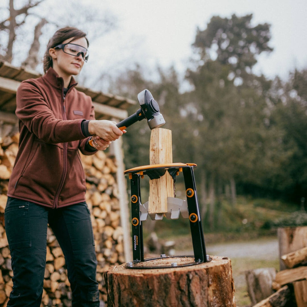 Строителен чук Fiskars IsoCore™ размер L в действие - жена с чук IsoCore удря къс дървен кол за цепене, намалява вибрации и умора