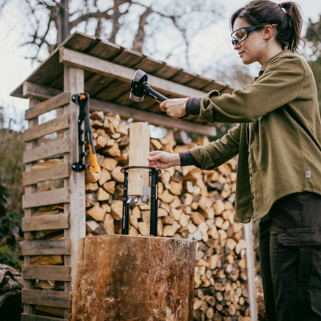Строителен чук Fiskars IsoCore™ размер M в ръка на работеща жена, удар към клин за разцепване на дърва, с намаляване на вибрациите
