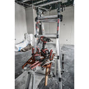 Работна платформа Little Giant с инструменти, разположени на стълба в строителен обект.