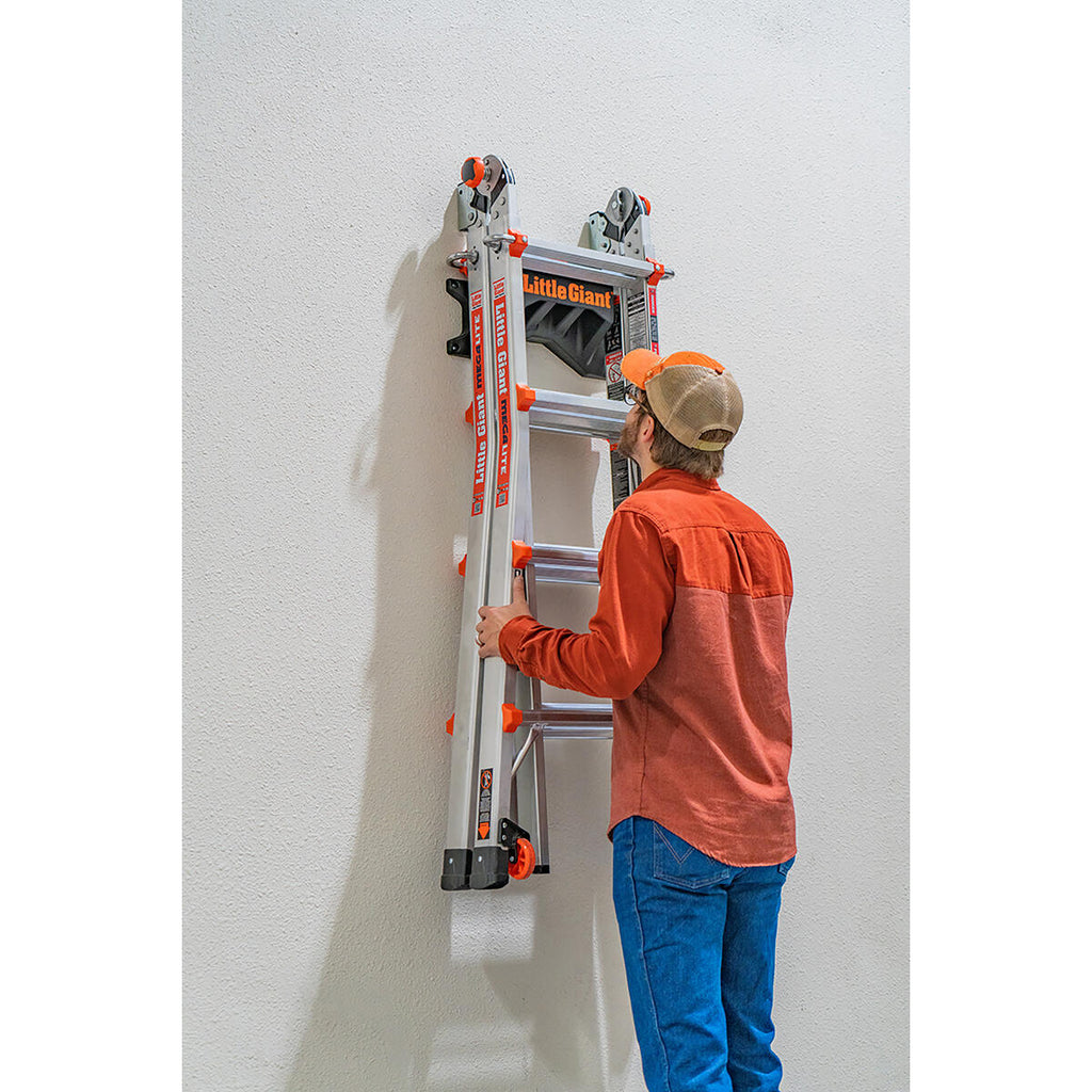 Човек монтира стойка за стълби Little Giant® Ladder Rack™ на стена за безопасно съхранение.