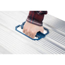 Ръка държи синя дръжка на алуминиева работна платформа Werner на неравна повърхност.