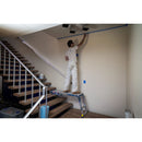 Работник използва алуминиева регулируема работна платформа WERNER за боядисване на стена близо до стълбище.