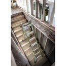 Телескопична стълба от фибростъкло Little Giant Dark Horse 2.0, поставена на дървено стълбище в строеж.