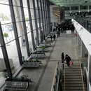 Вътрешен изглед на съвременен интериор с посетителски пейки и стъклени стени.