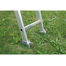 Опорни шипове за стълби KRAUSE, монтирани на естествена земя за безопасна професионална употреба.