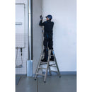 Работник на алуминиева стълба Krause STABILO, извършва работа на височина в професионална среда.