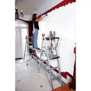 Жена боядисва стена в дом, стоейки на телескопична платформа от алуминий.