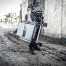 Мъж държи алуминиева стълба Little Giant Jumbo Step на строителен обект, демонстрираща лекота и стабилност.