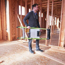 Мъж носи стълба с платформа от фибростъкло Little Giant MightyLite™ в строителен обект.