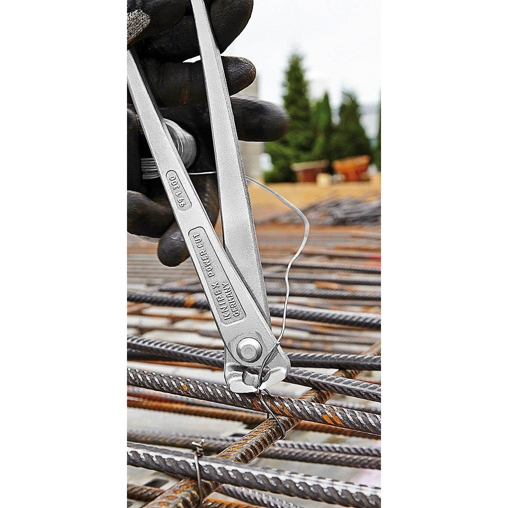 Арматурни клещи KNIPEX в действие, свързващи арматура с тел на строителен обект.
