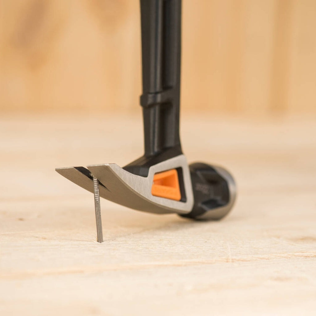 Универсален чук Fiskars IsoCore™ размер L с ударна глава и система IsoCore™ държи гвоздей в дърво