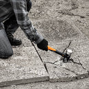 Строителен чук Fiskars IsoCore™ размер L в действие при чупене на бетонна настилка с анти-вибрационна дръжка
