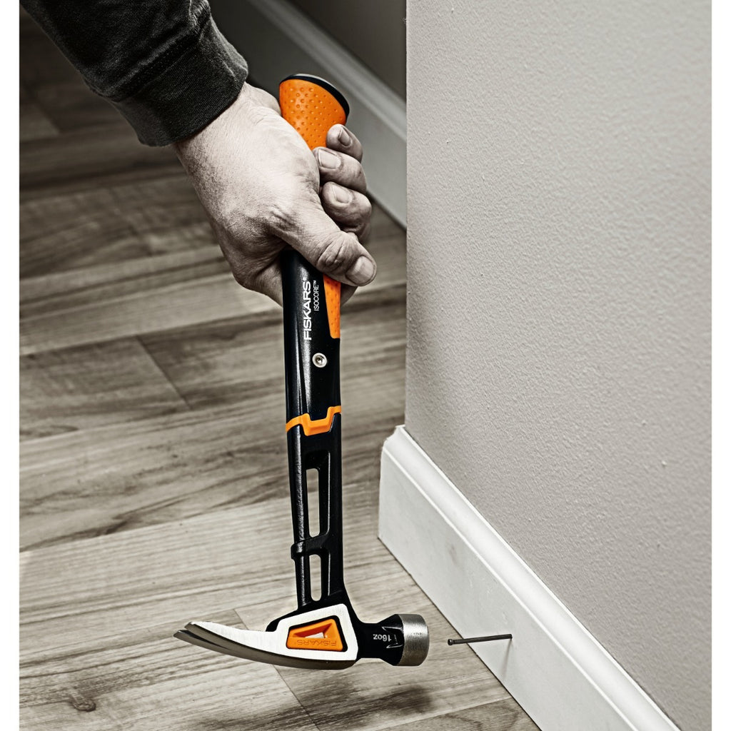 Универсален чук Fiskars IsoCore™, размер M в употреба при поставяне на пирон за довършителни работи