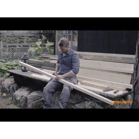 Универсален нож с вградено точило в канията Fiskars показан при рязане на дъски на открито, удобна дръжка и интегрирано точило