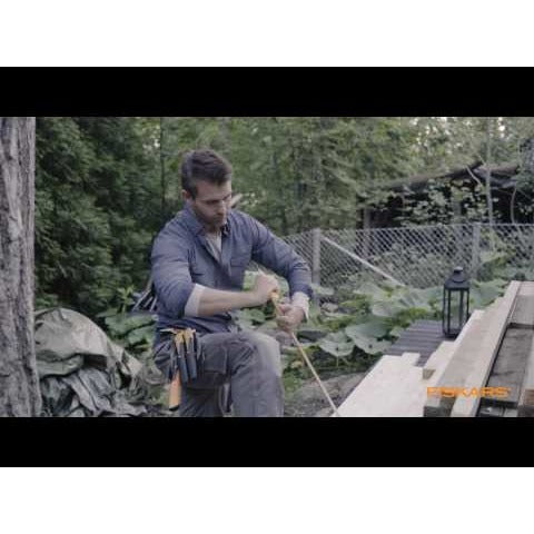 Нож с пила и вградено точило в канията Fiskars показан при външна работа с дърво и ергономична дръжка