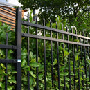 Оградна система ASPEN с черно ковано желязо, разположена сред зелени храсти.