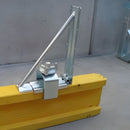 Скоба за окрайчване на кофражни плочи, изработена от горещо поцинкована стомана, монтирана на жълта дървена дъска.