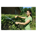 Жена реже храсти с ножици за храсти Fiskars PowerLever™ HS52 в градина.
