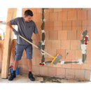 Човек използва стъргалка за кофражни платна за почистване на зидария.