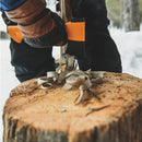 Брадва за къмпинг Fiskars в действие, разцепваща дърво на снежна фокусна точка.