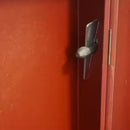 Дверна дръжка на червена врата, акцент на детайли и изработка.