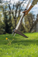 Изкоренител за плевели Light в действие, премахващ глухарчета от зелена морава.