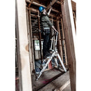 Работник на стълба с предпазен шлем в строителен обект, използващ стълба с 4 стъпала SAFETY STEP МАЛКИЯ ГИГАНТ®.