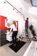 Двойка монтира осветление в баня с алуминиева стълба и огледало, уютно домашно пространство.