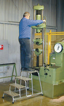 Работник, използващ алуминиева степенка KRAUSE STABILO за монтажни дейности в производствена среда.