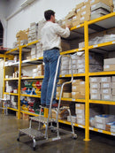 Работник на алуминиева стълба KRAUSE STABILO, достигайки до рафта, демонстрираща професионална употреба и немско качество.