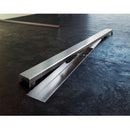 Плътна решетка DESIGN за линеен сифон от полирана неръждаема стомана, разположена на пода.