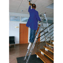 Работник на алуминиева трираменна стълба Krause Corda, монтира светилник на височина в офис.