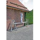 Мъж рисува върху стена с телескопична платформа от алуминий, демонстрираща немско качество и безопасност.