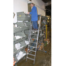 Работник на складова стълба KRAUSE STABILO 10, безопасно достъпващ високи рафтове.