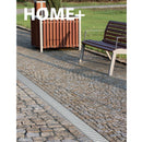 Външен дренажен канал с поцинкована решетка, използван в обществена зона с пешеходна пътека и мебели за сядане.