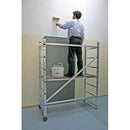 Мъж използва компактно алуминиево мобилно мини скеле KRAUSE за боядисване на стена с валяк.