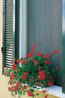 Цветна мрежа против комари с червени цветя на прозореца.