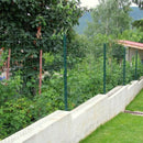 Оградна мрежа Pantanet Essential, висока 1.02 м, зелена, с множество храсти и дървета на заден план.