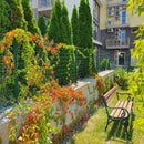 Ограда Pantanet Essential в градина, обградена с растения и пейка за почивка.