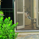 Стъклена врата с мрежа против насекоми, вижда се човек, който чете, в подреден интериор.