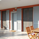 Външен изглед на патия с мрежа против насекоми Zanzibar, сиви щори и дървена маса.